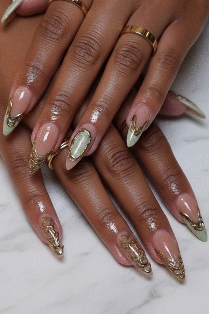 π
Channel Your Inner Goddess With This Opulent Nail Trend 9 Sage green nails with one accent nail featuring abstract gold leaf details. DIY nail art for a grounded Goddess Energy Aesthetic.